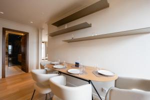 a dining room with a table and white chairs at Le Nid du Favre II - Large 2 room with breathtaking view of the lake in Annecy