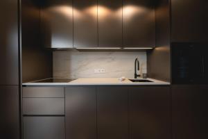 a kitchen with white cabinets and a sink at Le Nid du Favre II - Large 2 room with breathtaking view of the lake in Annecy