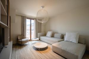 a living room with a couch and a table at Le Nid du Favre II - Large 2 room with breathtaking view of the lake in Annecy +34 photos