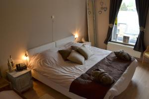 Un dormitorio con una cama blanca con almohadas y una ventana. en Auberge Le Relais, en Corbion 48 fotos más