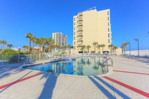 a swimming pool in front of a large building at Ocean Front Penthouse Suite Panoramic Views of Gulf,Pensacola Beach,Pier, & Bay in Pensacola Beach