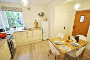 cocina y comedor con mesa de madera y sillas en 14 Union Street en Kirkcudbright