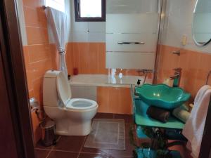 y baño con aseo, bañera y lavamanos. en Mani spot in Yerolimin, en Yerolimin