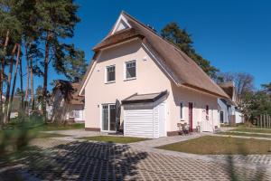 a white house with a gambrel roof at Ferienhaus "Reet-Traum" in Zirchow