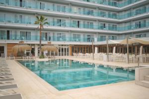 a hotel swimming pool with chairs and umbrellas at Hotel Bahia del Sol in Santa Ponsa