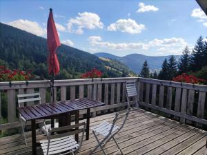 旺特龍的住宿－Maison de montagne vue magnifique，木甲板上配有野餐桌和遮阳伞