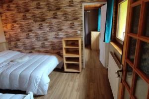 um quarto com uma cama e uma parede de tijolos em Maison de montagne vue magnifique em Ventron