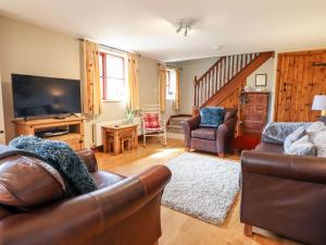 a living room with two couches and a television at Beudy Penarddwnion in Dolgellau