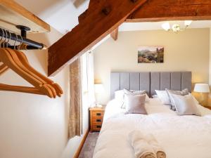 een slaapkamer met een groot bed met witte lakens bij Beudy Penarddwnion in Dolgellau