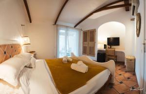 um quarto com uma cama grande e toalhas em Hôtel Palombaggia em Porto-Vecchio