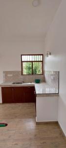 a white kitchen with a sink and a window at Zentinal in Unawatuna