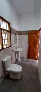 a bathroom with a toilet and a sink at Zentinal in Unawatuna