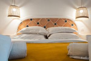 a bedroom with a large white bed with two lights at Hôtel Palombaggia in Porto-Vecchio