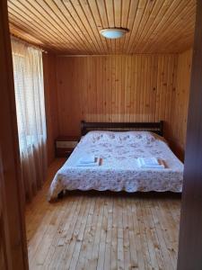 una camera da letto con letto in una camera in legno di Зачаровані Карпати, Воловець a Volovets