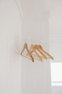 a cluster of wooden hangers hanging from a wall at The Sunsetter by WB Abodes in Wrightsville Beach