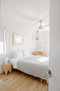 ein weißes Schlafzimmer mit einem großen Bett in einem Zimmer in der Unterkunft The Sunsetter by WB Abodes in Wrightsville Beach