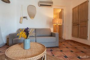 a living room with a couch and a table at Hôtel Palombaggia in Porto-Vecchio