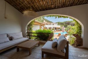 a living room with a couch and a table at Hôtel Palombaggia in Porto-Vecchio