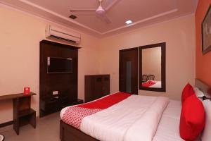 a bedroom with a large bed and a television at OYO 16147 Hotel Jyoti Continental Agra in Tājganj