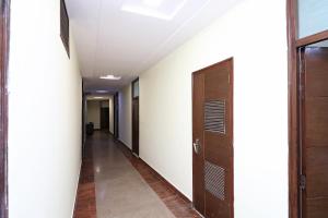 a corridor of an office building with wooden doors at OYO 16147 Hotel Jyoti Continental Agra in Tājganj