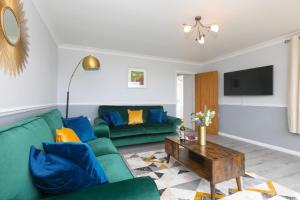 a living room with a green couch and a table at Ocean Air in Carbis Bay
