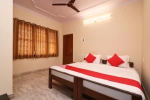 a bedroom with a large bed with red pillows at Flagship Hotel Midtown in Bhopal