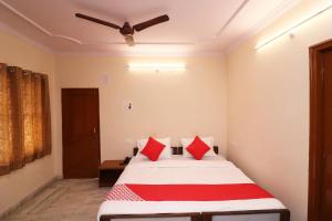 a bedroom with a bed with red pillows and a ceiling at Flagship Hotel Midtown in Bhopal