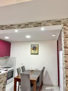 a kitchen and dining room with a table and chairs at Apartman Guberinic,Tivat ,trosoban stan in Tivat