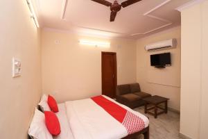 a small bedroom with a bed and a chair at Flagship Hotel Midtown in Bhopal