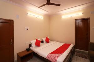 1 dormitorio con cama con almohadas rojas y techo en Flagship Hotel Midtown, en Bhopal