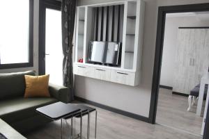 a living room with a couch and a tv on a wall at Kaya Home Apart Otel in Trabzon