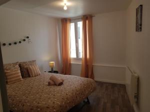 1 dormitorio con cama con almohada y ventana en St junien n:2, en Saint-Junien