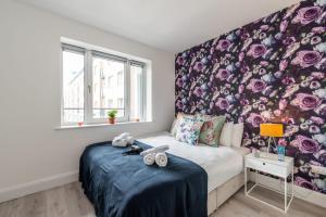 a bedroom with a bed with a floral wall at Sweet Inn - Adelaide Square in Dublin