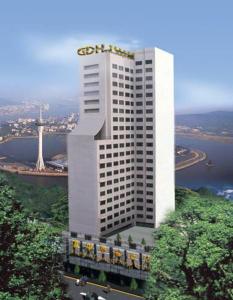 Un grand bâtiment blanc avec un panneau en haut dans l'établissement Fu Hua Hotel, à Macao