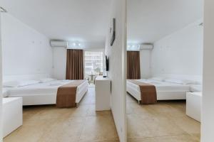 a room with two beds and a mirror at MonteCasa Seaview Rooms in Dobra Voda
