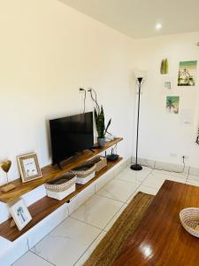 a living room with a flat screen tv on a white wall at Casa Blanca Beachhouse - walking distance beach in Tamarindo