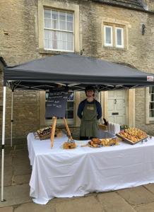 a woman standing in front of a table with food at Alexander House in Corsham