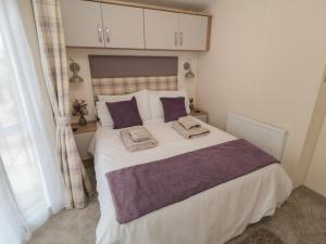 um quarto com uma cama grande e almofadas roxas em Stag Lodge em York