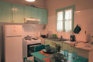 a kitchen with green cabinets and a white refrigerator at Mojo Studios Parga in Parga