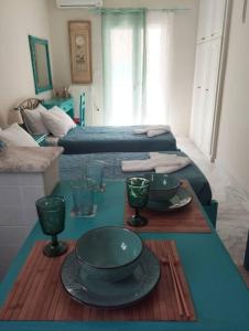 a living room with two beds and a table with plates at Mojo Studios Parga in Parga