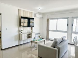 un soggiorno con un divano e un tavolo di VENETO V DEPARTAMENTOS a Villa Carlos Paz