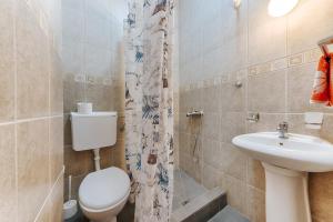 a bathroom with a toilet and a sink and a shower at MonteCasa Seaview Rooms in Dobra Voda
