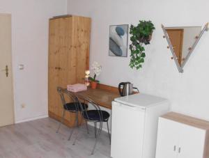 a kitchen with a table and chairs and a refrigerator at Cozy Zimmer inkl Parkplatz nach Verfügbarkeit in Essen