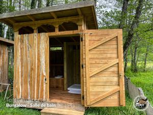 an open door to a wooden outhouse with a gate at Parc animalier du Hérisson in Doucier