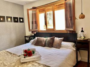 a bedroom with a bed with flowers on it at Hostal Nomadas by Gloove in Villalba de la Sierra