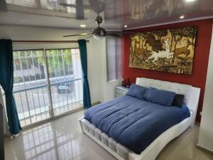 een slaapkamer met een bed met een schilderij aan de muur bij Prefect get away in Santa Marta