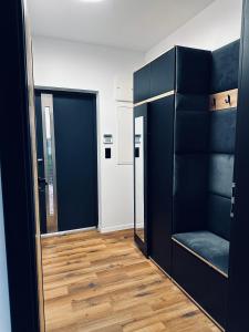 Habitación con estanterías negras y suelo de madera. en Apartament u Heleny, en Sosnówka