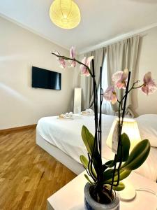 a room with a bed and a vase with flowers at Lovely Lucca [free parking] in Lucca