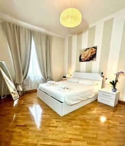 a bedroom with a white bed and a large window at Lovely Lucca [free parking] in Lucca