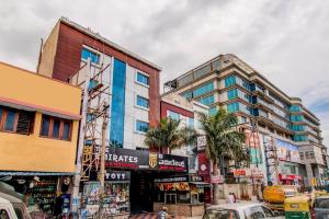 a busy city street with cars and buildings at Capital O 5381 The Emirates Hotel in Bangalore